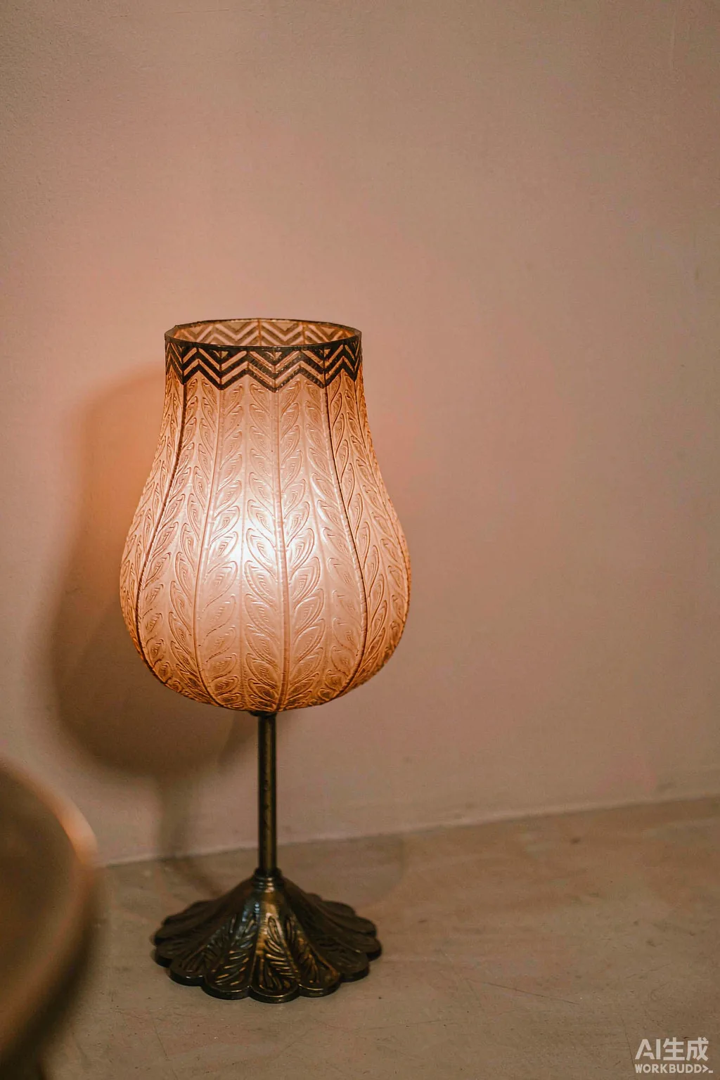 A metal lamp shade glowing on a floor lamp against a pale wall