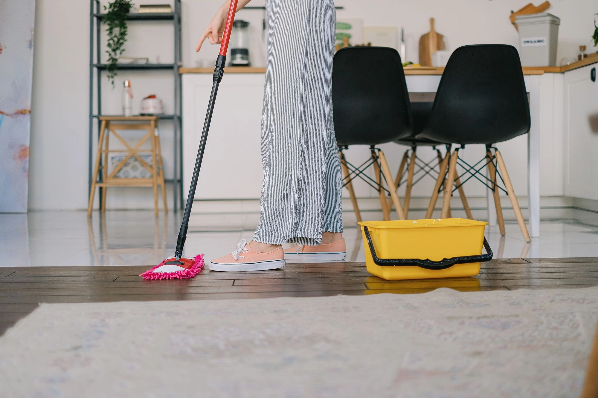 A person cleaning a kitchen floor with a conventional mop; cleaning context, not a FEPPO product photograph
