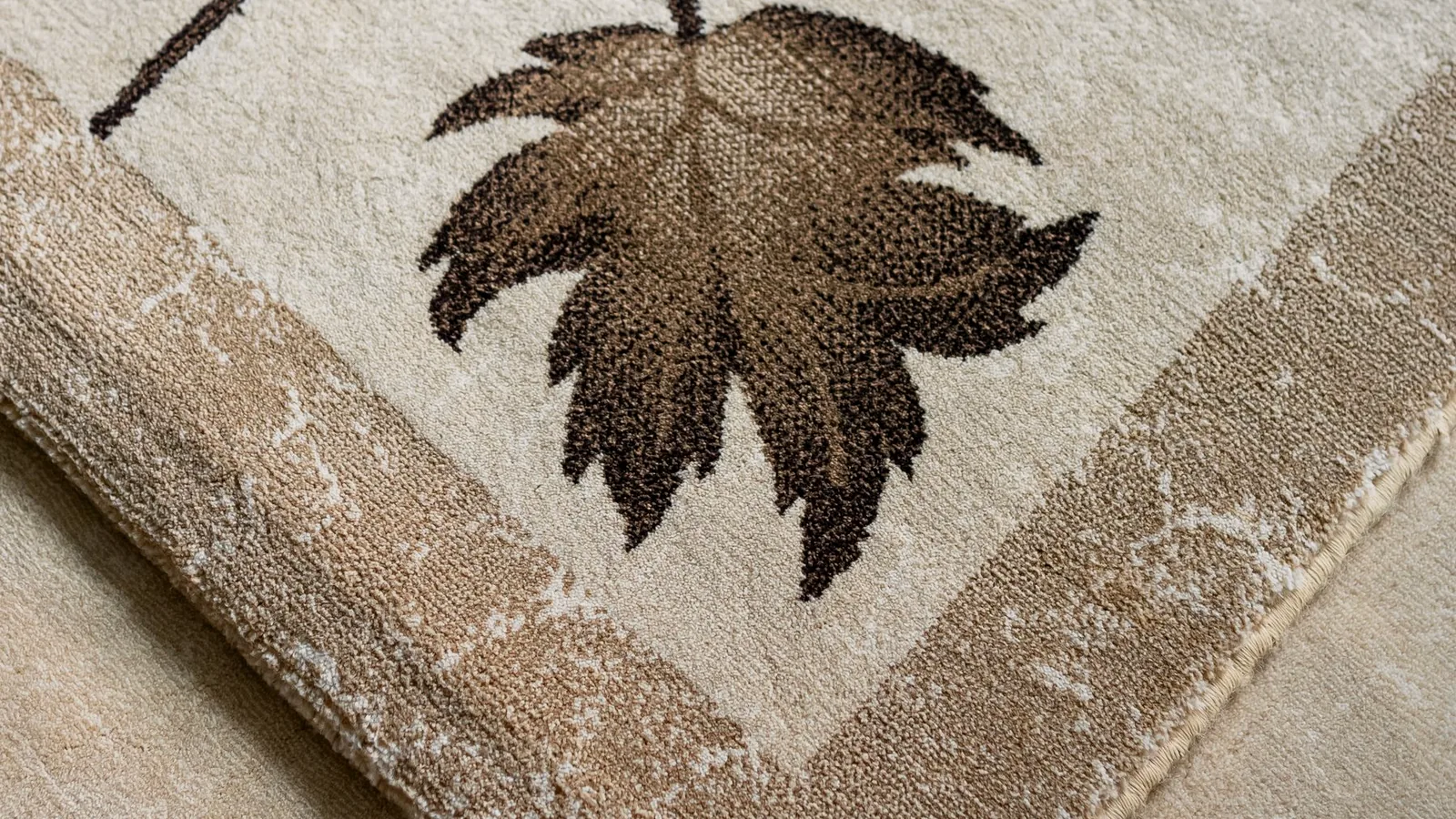 A beige rug with a leaf pattern, seen up close