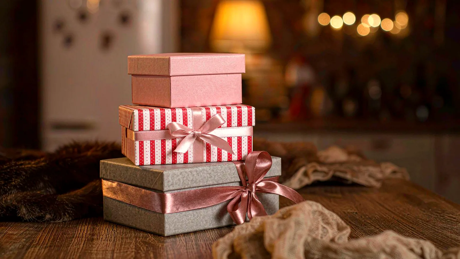 A small stack of wrapped gift boxes on a wooden table