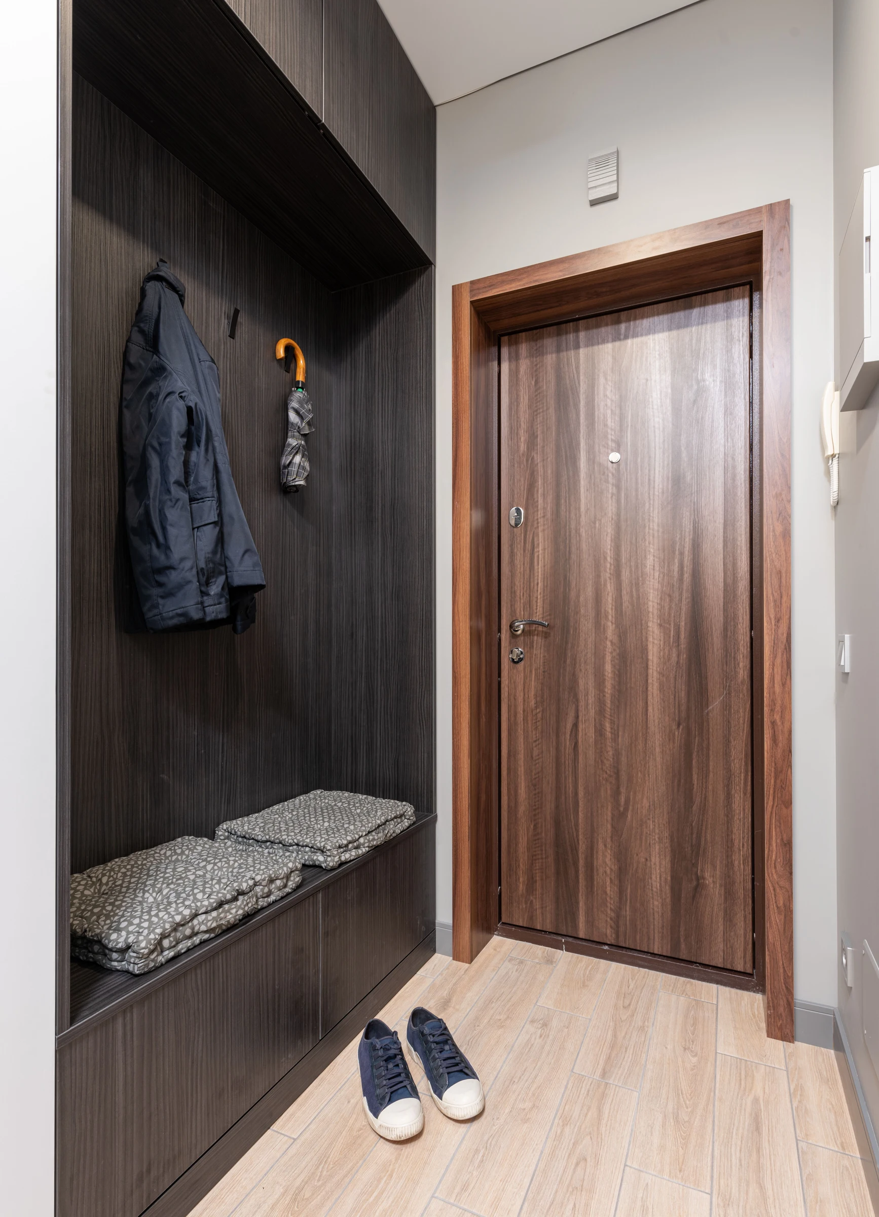 An entryway with a bench, hanging storage and shoes; layout context.
